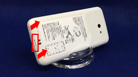 説明図：スマートフォンの背面写真にツメに指をかけ、外側に向かって矢印が示してある図