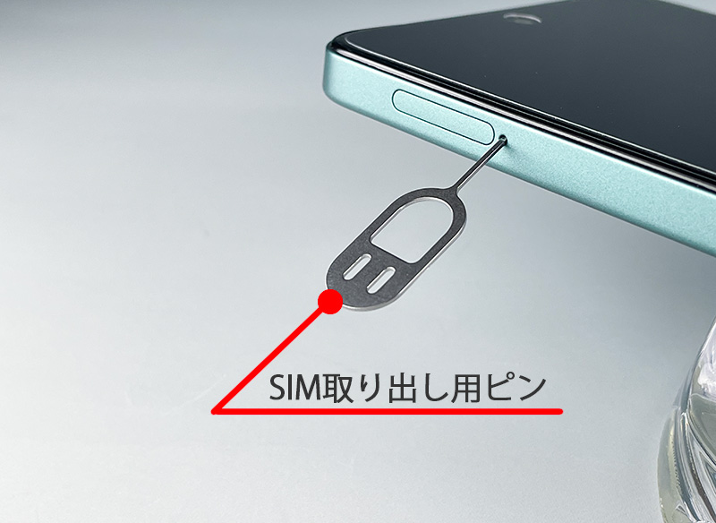 説明図：SIM取出し用ピンを差し込んだ画像