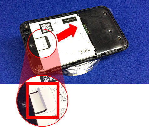 説明図：電池パックのつまみの場所を示した画像。