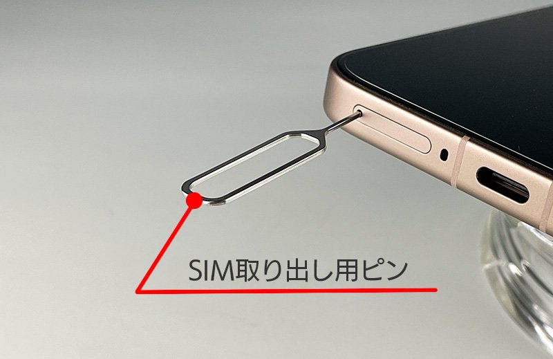説明図：SIM取出し用ピンを差し込んだ画像